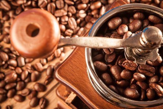 Vintage manual coffee grinder with coffee beans on wood table