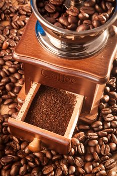 Vintage manual coffee grinder with coffee beans on wood table