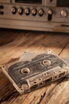 Old cassette tapes and cassette player on wooden surface