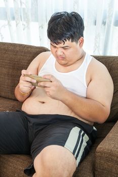 Fat asian man play game with his smartphone