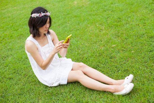 Asian woman using mobile smart phone in the park