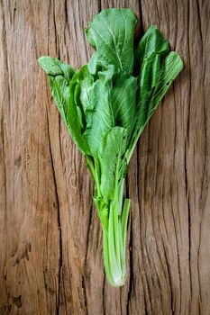 Bunch of fresh kale over old wooden background