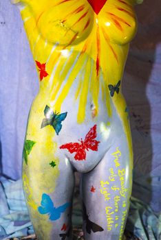 front of an multi colored artistic painted female mannequin torso