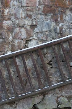 Old wooden ladder on a stone wall