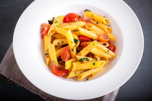 Penne with anchovy and tomato in a white plate