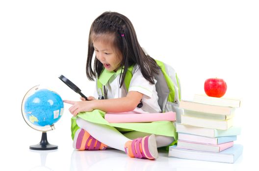 little asian girl looking through magnifying glass at globe, isolated on white background. School, education concept.