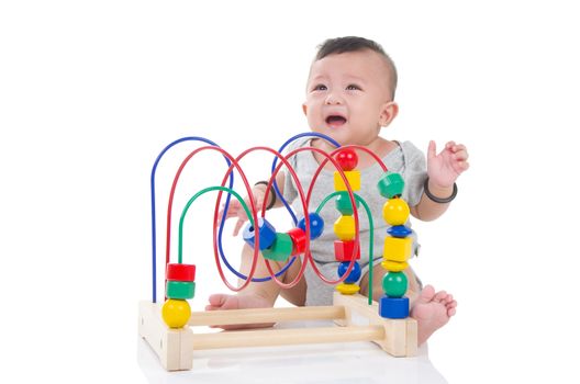 Cute asian boy crying and sitting on the floor, playing with toy.