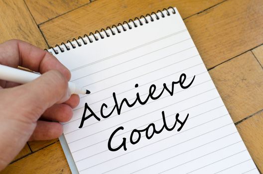 Achieve goals text concept write on notebook