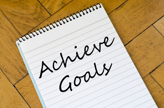Achieve goals text concept write on notebook