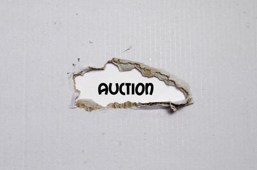 The word auction appearing behind torn paper