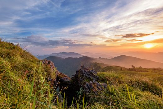 Beautiful landscape nature on peak mountain with sun cloud fog and bright colors of sky and sunlight during sunset in winter at viewpoint Phu Chi Fa Forest Park in Chiang Rai Province, Thailand