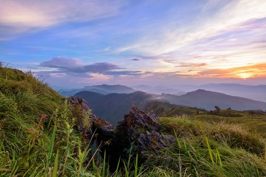 Beautiful landscape nature on peak mountain with sun cloud fog and bright colors of sky and sunlight during sunset in winter at viewpoint Phu Chi Fa Forest Park in Chiang Rai Province, Thailand