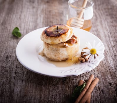 Baked apple with nuts and raisins on a wooden surface