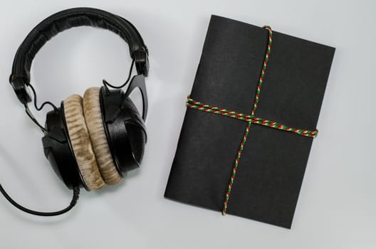 Headphone and notebook front cover on white background