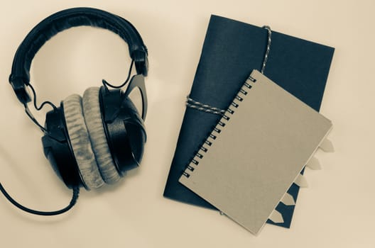 Headphone and notebook front cover on white background