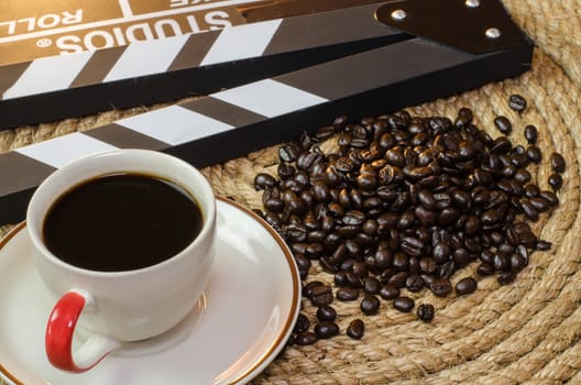 Cup of hot coffee with coffee beans slate on a jute rope.