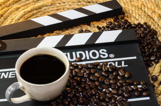 Cup of hot coffee with coffee beans slate on a jute rope.