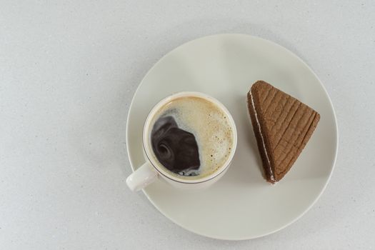 A cup of coffee with slice of chocolate cake on White background