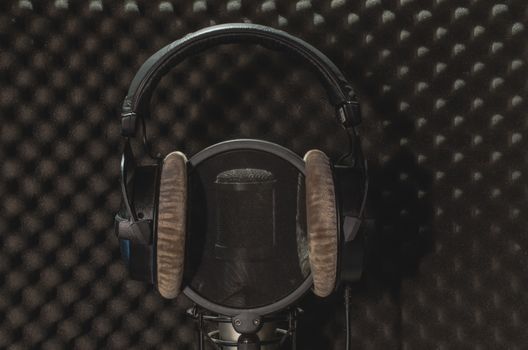 Headphone and microphone recording studio on a black background.