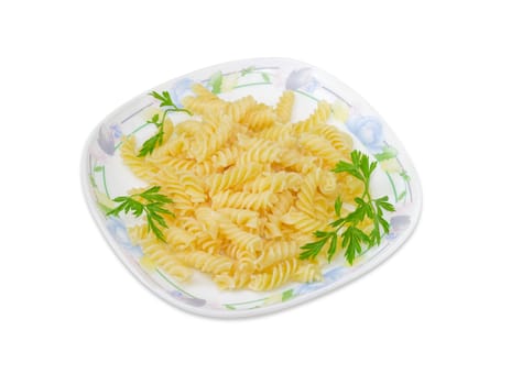 Cooked spiral pasta decorated with a several small parsley twigs on a dish on a light background
