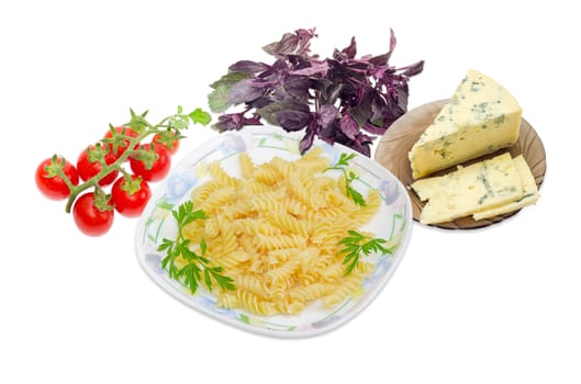 Cooked spiral pasta and the parsley twigs on a dish, cluster of the red cherry tomatoes, blue cheese on a glass saucer and bundle of the purple basil on a light background
