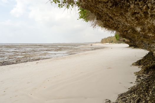 Small cove with a rock on the white sand of the bamburi beach in Mombasa, Kenya