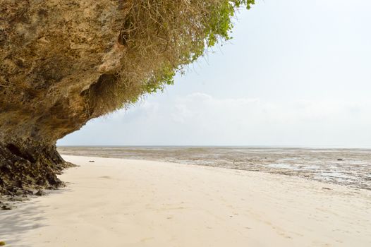 Small cove with a rock on the white sand of the bamburi beach in Mombasa, Kenya