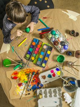 Photo of a brother and sister painting and decorating hard-boiled eggs for easter.