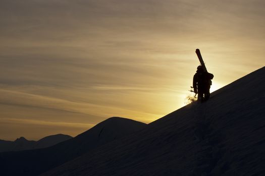 Skier on the background of sunset in the mountains