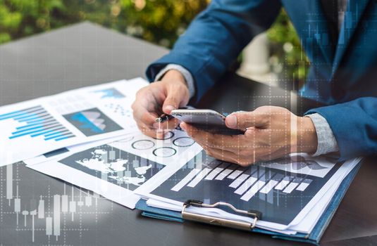 Handsome businessman wearing suit and using modern laptop outdoors and graph finance diagram