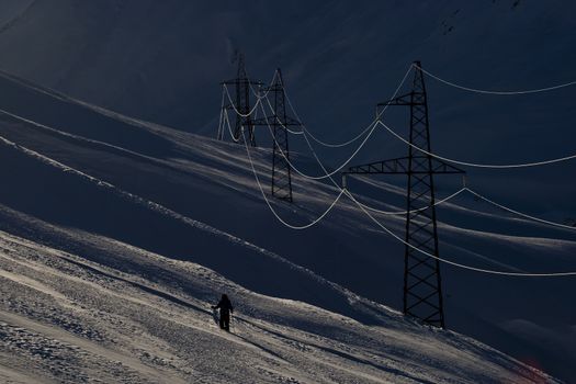 Power supply line in winter evening. Georgia mountains