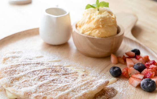 fresh dessert soft vanila roti with ice cream ,syrup ,strawberry and blueberry on plate in restaurant ,selective focus