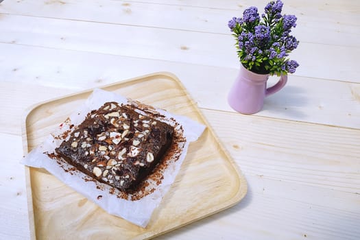 Brownie on dish wood  with  Purple Little Flower in Pot