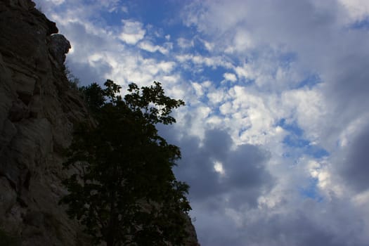 textured rock wall against a blue sky.