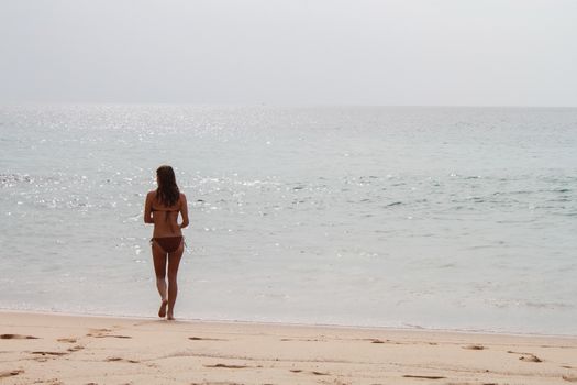 walking woman on a tropical sea beach. Vacations on sea shore