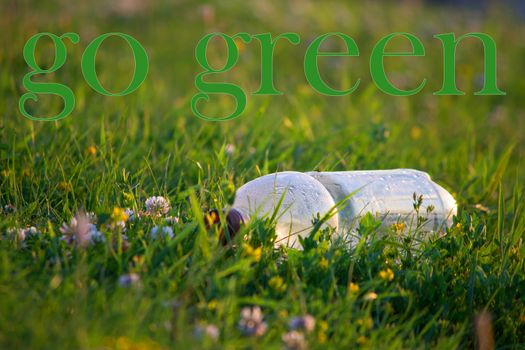 empty plastic bottle on a background of green grass