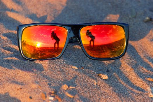 Soft focus on sunglasses reflection of girl boy and dog on it