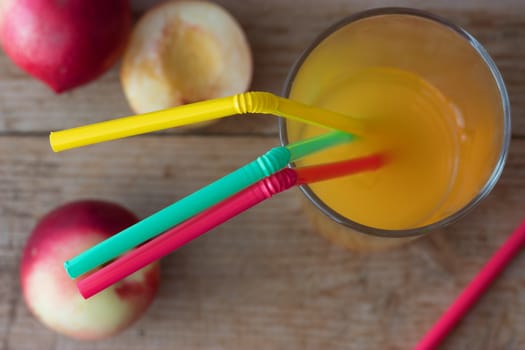 Ripe peaches and glass of juice on wooden background