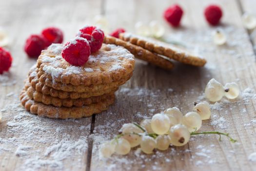 cookie and fresh raspberry on wooden background