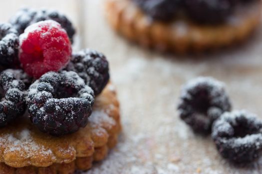 Fresh berry tartlet or cake filled with raspberry blackberry icing