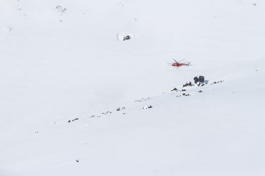 The helicopter on the snow of Kamchatka mountains