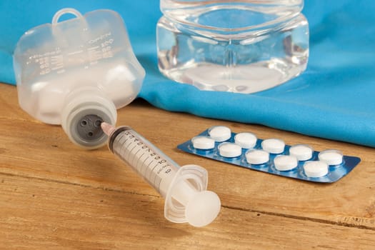 drug and saline solution and injection needle on wood table