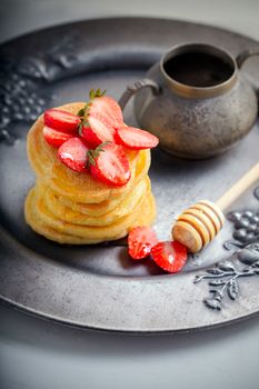 Stack of sweet pancakes with strawberry and honey. Gluten free flour.