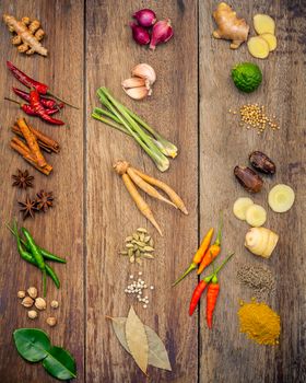 Various of Indian spices and herbs. Cooking ingredients and red curry paste . Ingredients of thai popular food on rustic wooden background. All spices with flat lay.