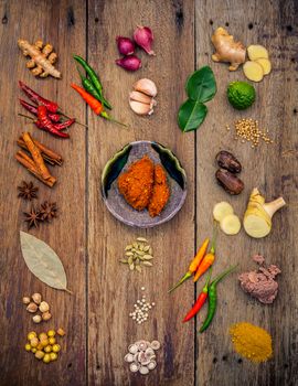 Various of Indian spices and herbs. Cooking ingredients and red curry paste . Ingredients of thai popular food on rustic wooden background. All spices with flat lay.