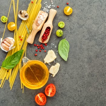 Italian food concept. Spaghetti with ingredients sweet basil ,tomato ,garlic peppercorn ,champignon,zucchini and parmesan cheese on dark background flat lay and copy space.