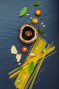 Italian food concept. Spaghetti with ingredients sweet basil ,tomato ,garlic peppercorn ,champignon,zucchini and parmesan cheese on dark background flat lay and copy space.