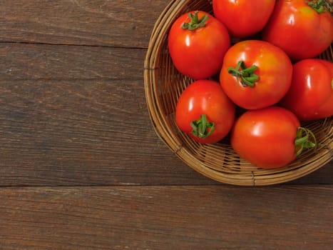 tomatoes in basket on wooden background