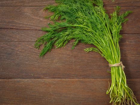 Dill is placed on a wooden table.