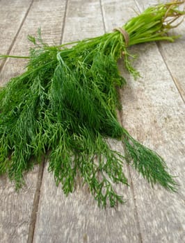 Dill is placed on a wooden table.